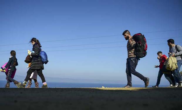 Syrian refugees walk up to the hill after arriving on the Greek island of Lesbos after crossing the Aegean Sea from Turkey (Photo: AFP) Syrian refugees walk up to the hill after arriving on the Greek island of Lesbos after crossing the Aegean Sea from Turkey (Photo: AFP)